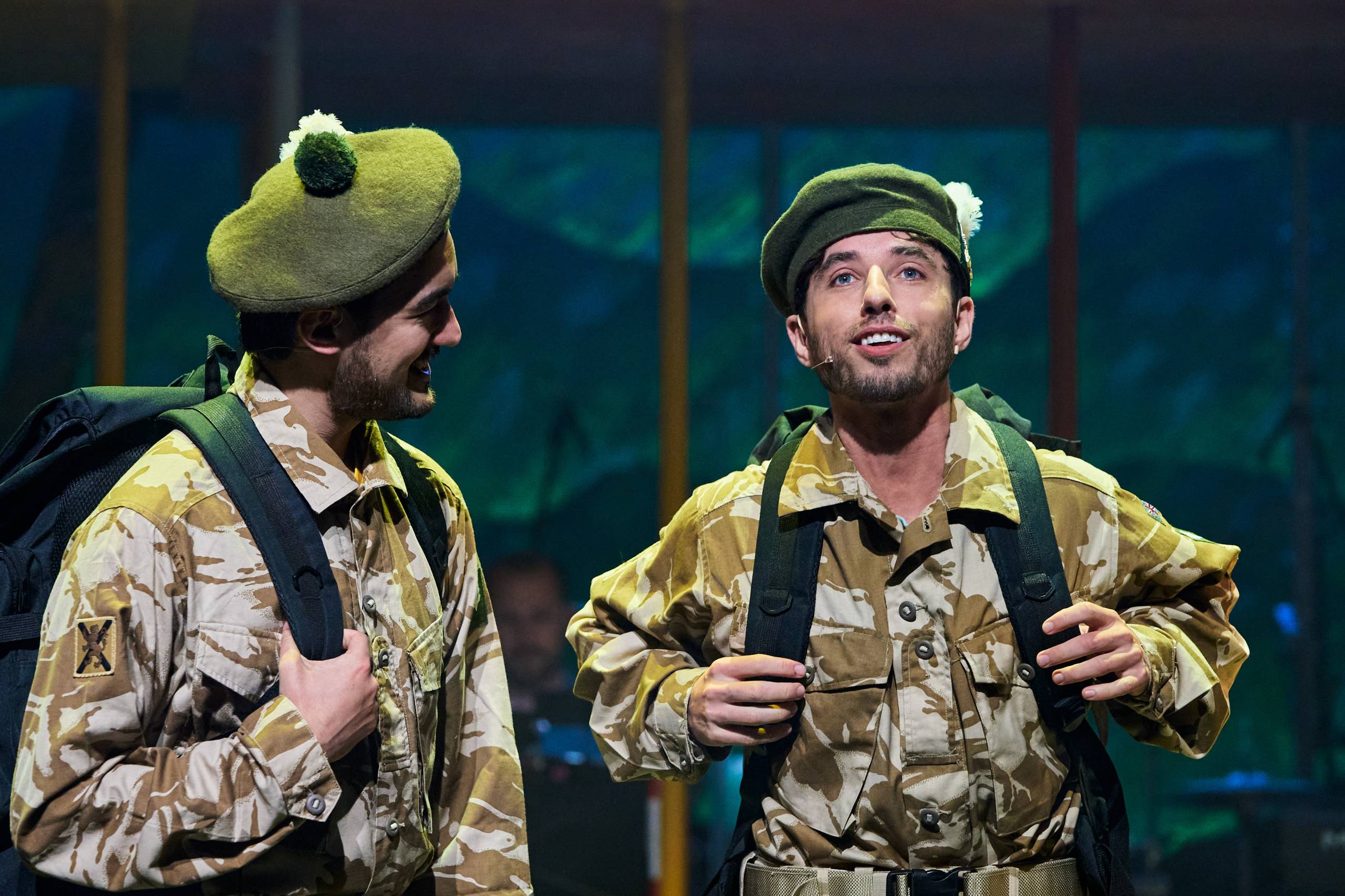 2 people on stage dressed in army uniform.